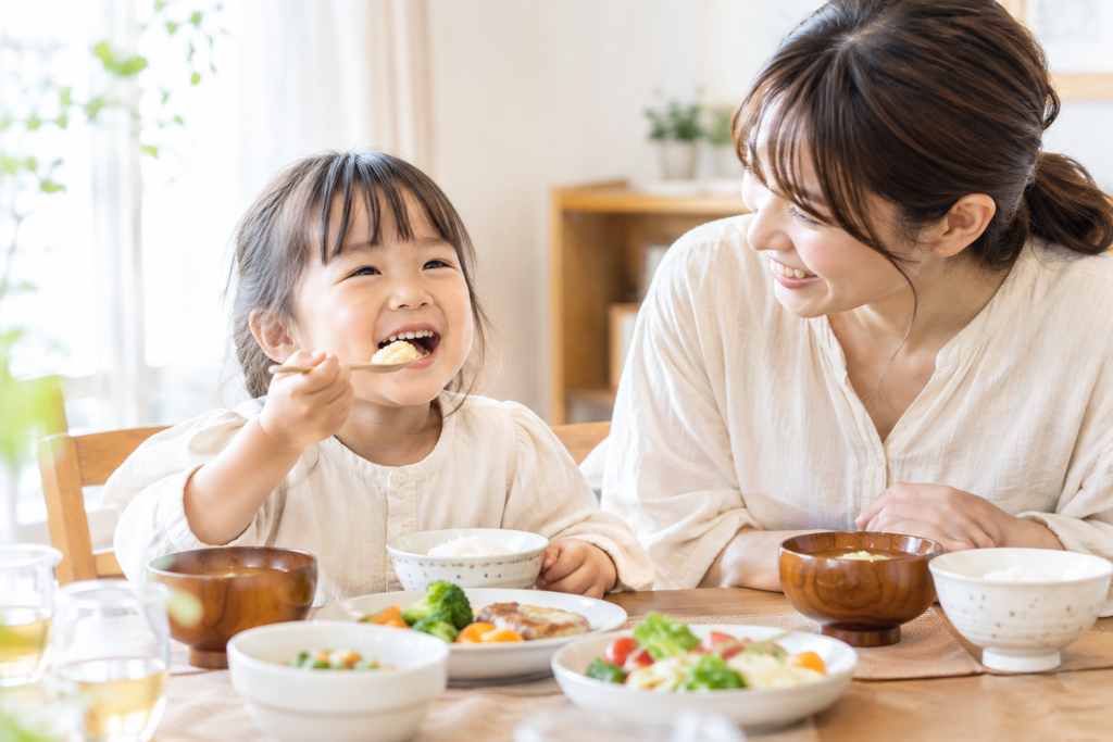食事を楽しむ子どもを見守る親子