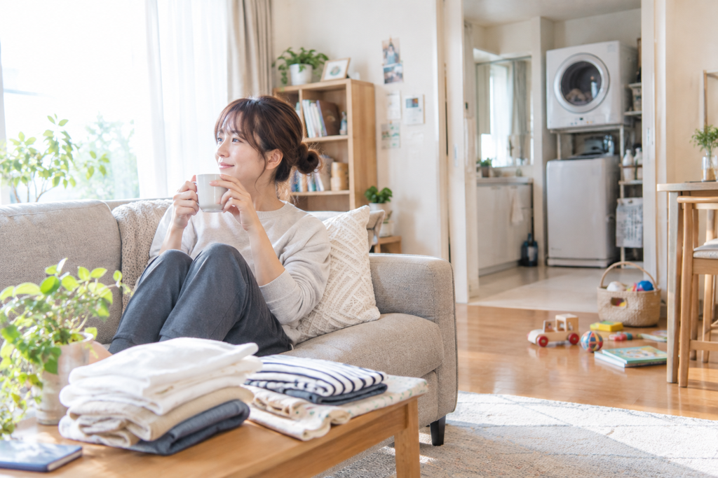 乾燥機で洗濯物を乾かしている間、リラックスして過ごす女性